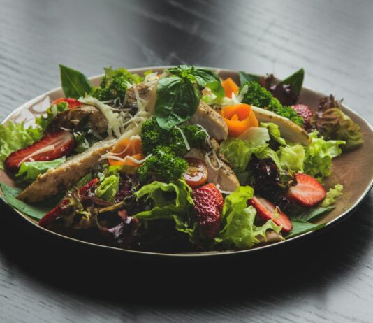 근육 회복과 성장을 위한 운동 후 식사법: 영양의 중요성 a plate of salad on a wooden table