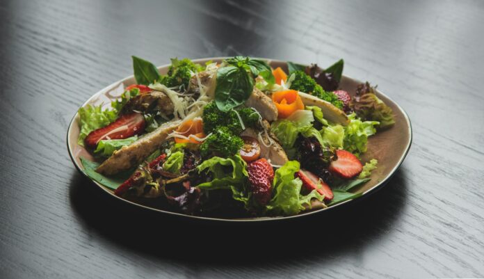 Photo by amin ramezani a plate of salad on a wooden table