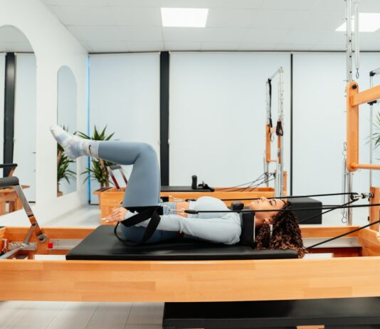 필라테스로 에너지 회복하여 만성 피로 극복하기 a woman is doing a pivot on a pivot machine