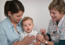 미국, 아동 백신 접종 일정 변경 논란… 정치 개입 우려 커져 a baby being examined by a doctor and nurse