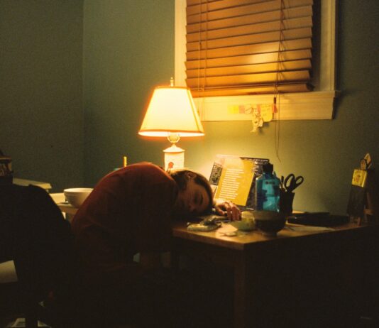 만성피로, 단순한 피로 아냐… 일상까지 무너뜨리는 건강의 적 a person sitting at a desk in front of a lamp