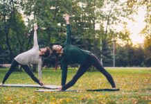 일과 삶의 경계가 흐려지는 시대의 회복 루틴: 직장인 스트레스와 건강 Two women practicing yoga in a park.