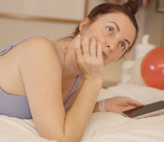 만성피로, ‘작은 생활 혁신’이 시작이다 Woman lying on bed with phone and balloons