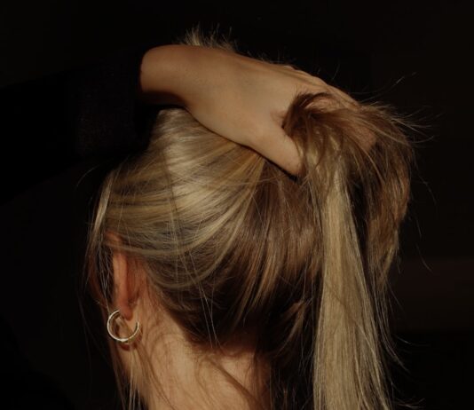 탈모 예방부터 두피 관리까지, 건강한 머릿결을 위한 생활 루틴 a woman with her hair in a bun