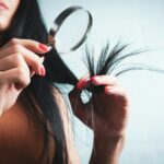 건강한 헤어 관리법, 일상 속에서 실천하는 트렌드 따라잡기 Woman examining split ends of hair with magnifying glass