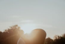 “건강하게 하루를 시작하는 작은 변화, 아침 스트레칭이 주는 선물” woman in white bikini bottom kneeling on green grass field during sunset