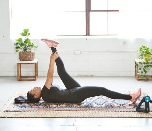웰니스 회복, 현대인의 필수 건강 전략으로 떠오르다 woman in black tank top and black leggings lying on black and white floral area rug